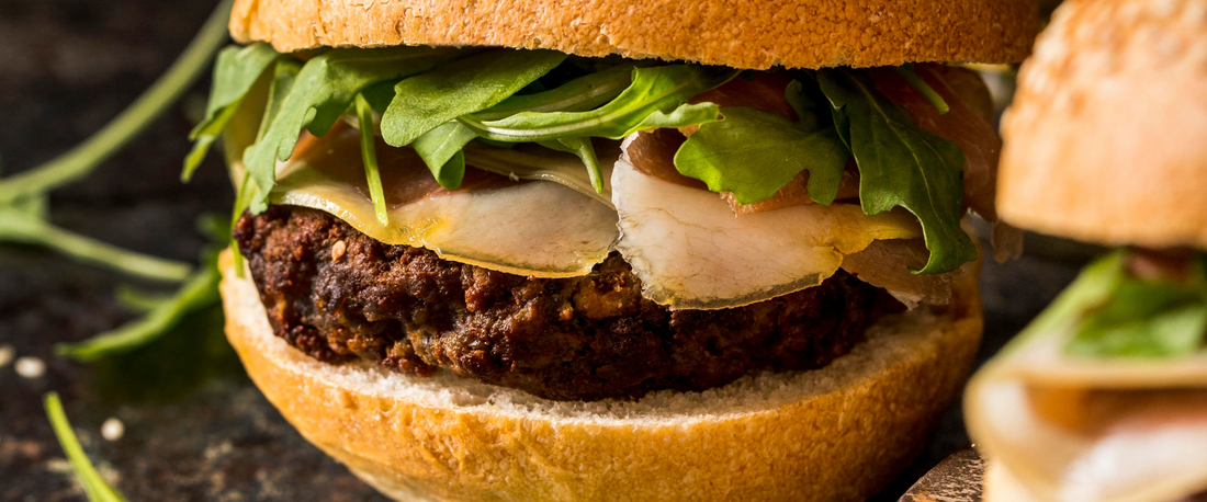 Burger di legumi Legù con rucola e verdure fresche servito in panino artigianale.
