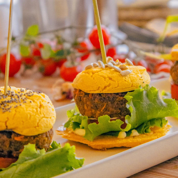 Mini burger di Mix Burger LEGÙ a base di legumi, senza glutine. Piatto cucinato con proteine vegetali, lattuga fresca e pomodoro su un vassoio bianco.
