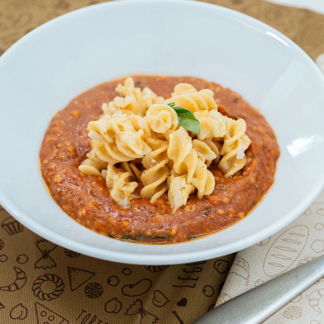 Piatto di fusilli con Ragù Veg di LEGÙ, un condimento di legumi dal colore intenso, ricco di proteine vegetali e senza glutine per una cena sana.
