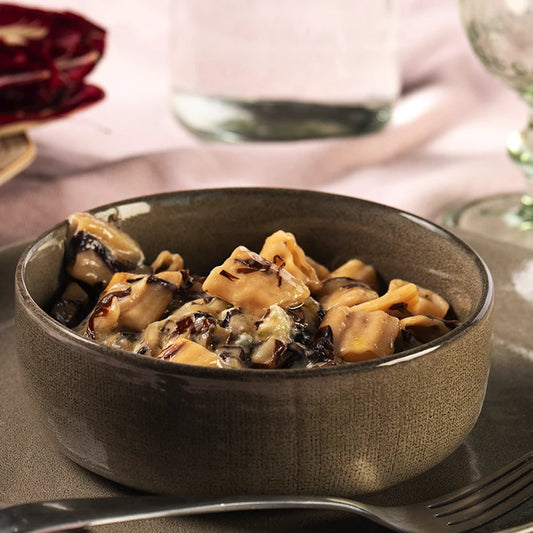 Plato cocinado de Rústicos ÚNICA LEGÚ maíz blanco y garbanzos. Pasta sin gluten con proteínas vegetales, presentada en bol beige sobre fondo elegante.