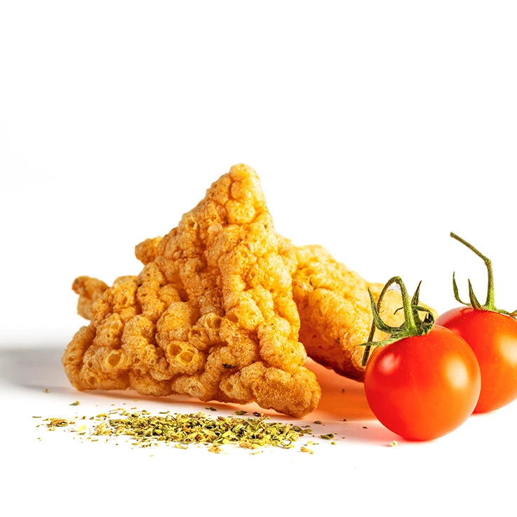 Triangoli Pizzaiola LEGÙ: snack dorati e croccanti di legumi senza glutine e ad alto contenuto di proteine vegetali, con pomodorini e origano su fondo bianco.